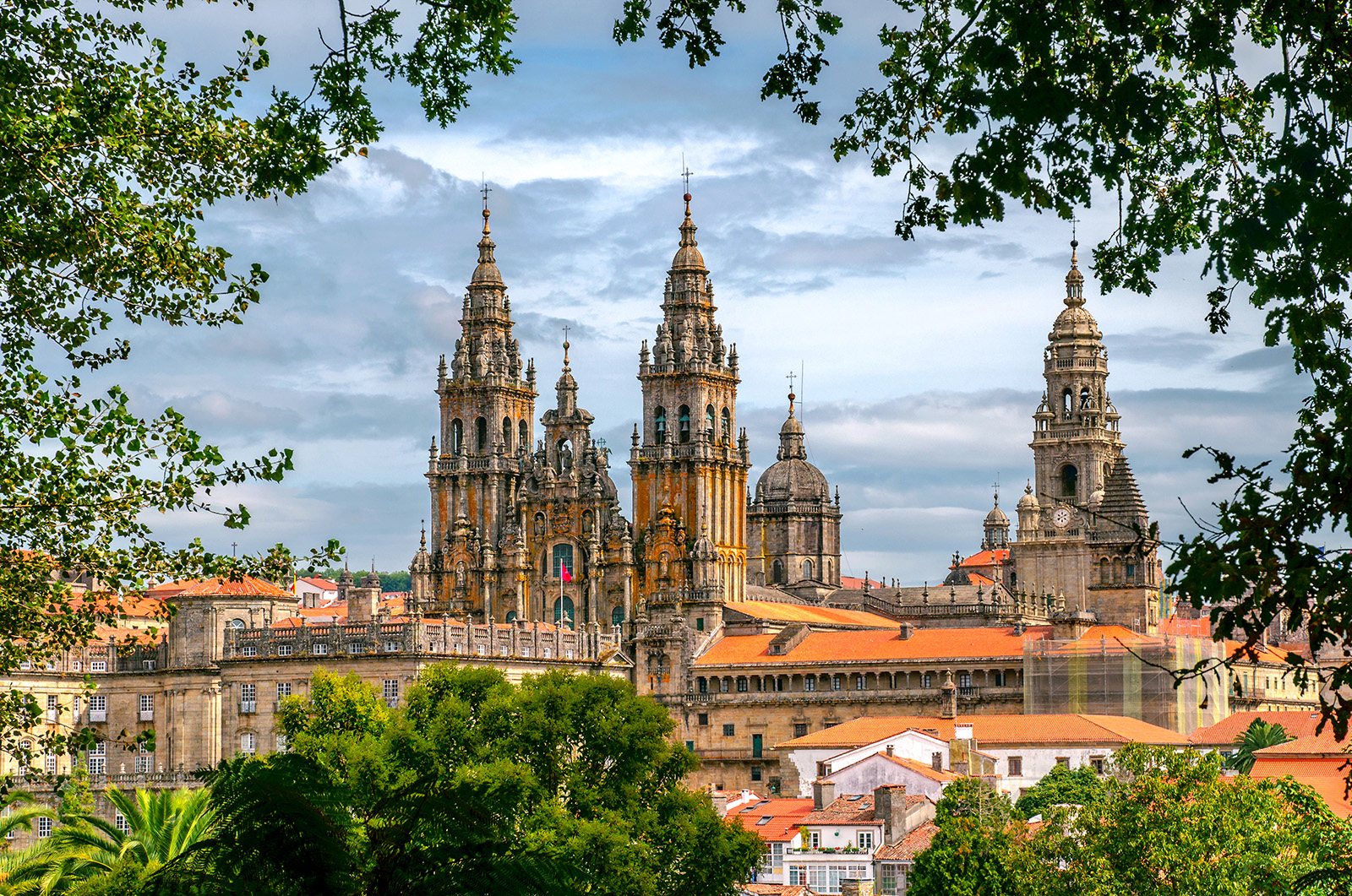 POV shot of Cathedral of Santiago de Compostela, taken from distant treeline.