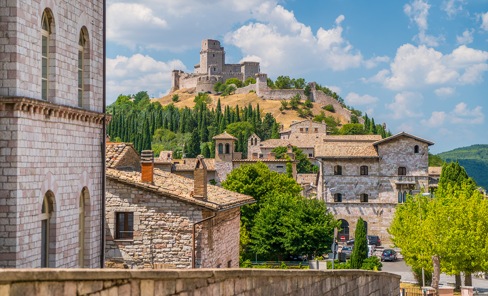 Wide shot of brick villages, large brick building on hilltop.