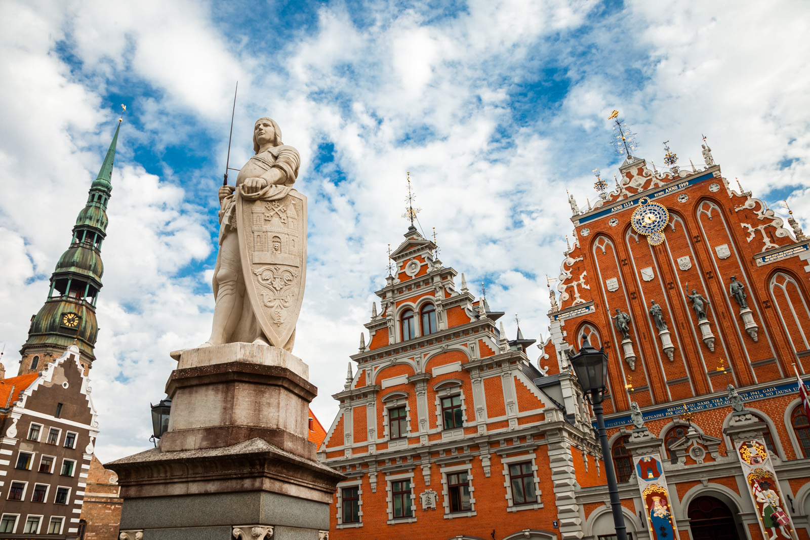 large stone statue stands in front of red brick building