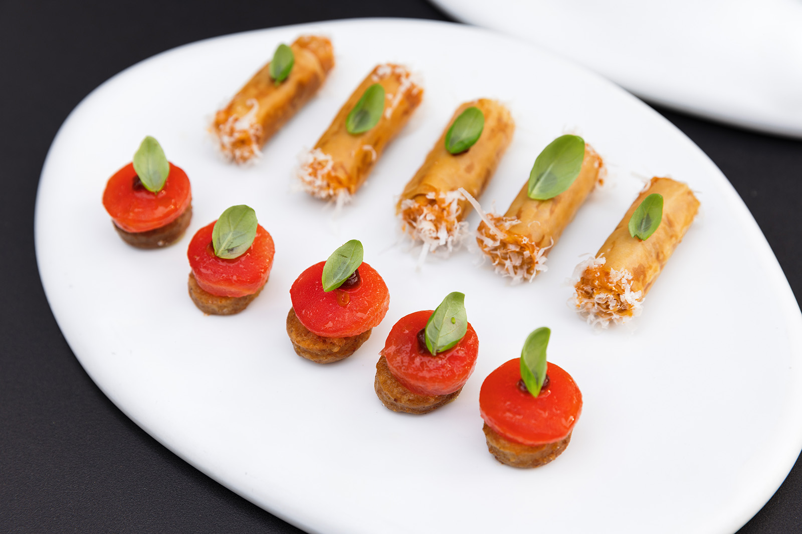 Red and orange micro dishes lined up on a plate