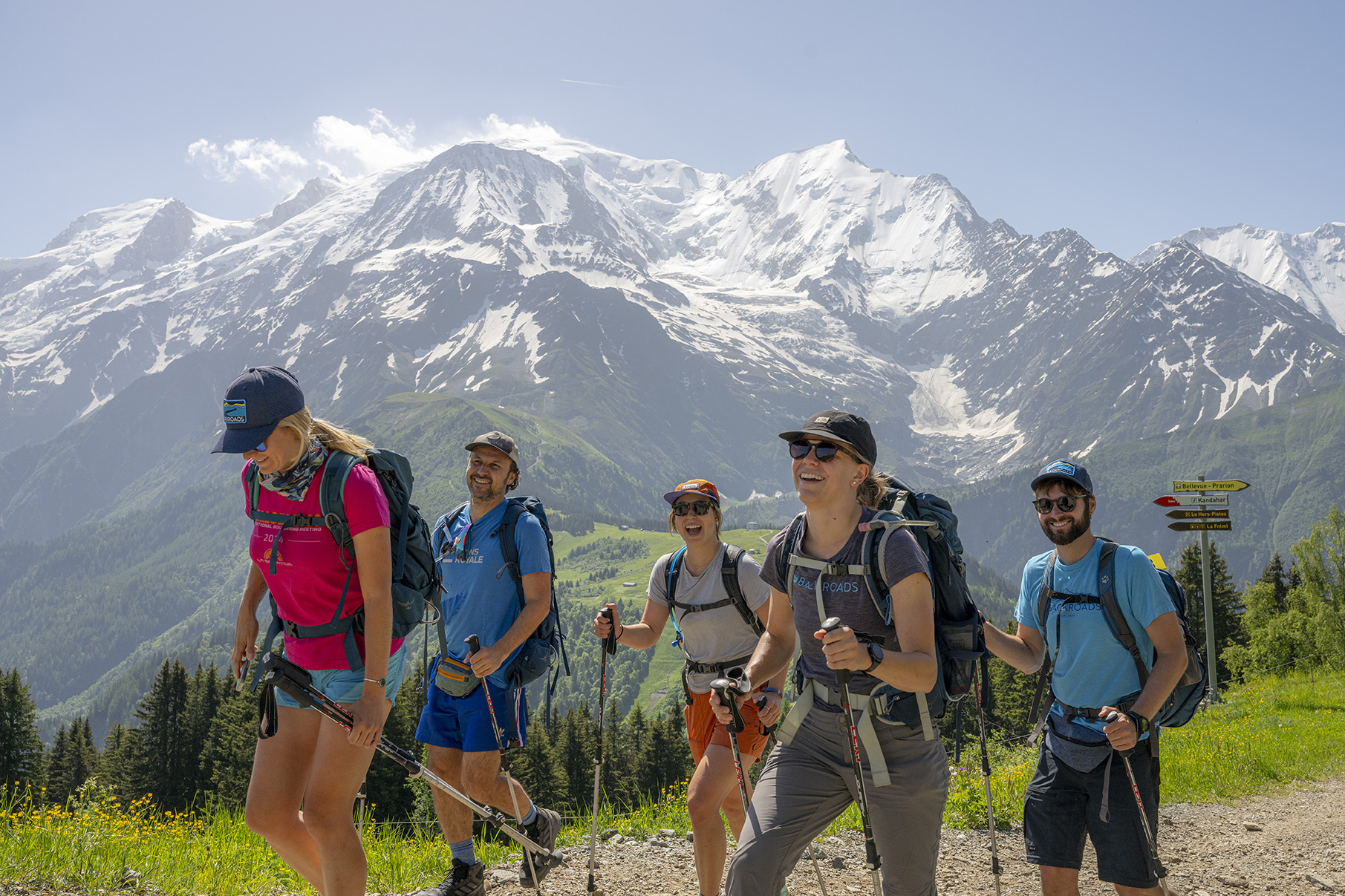 Group of people wearing backpacks, hiking on a trail