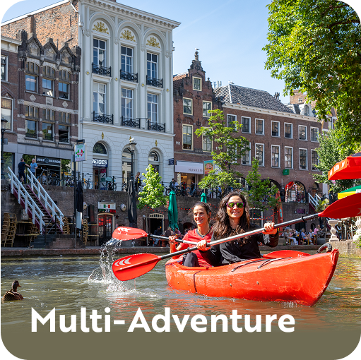 Two women paddling an orange kayak in a canal