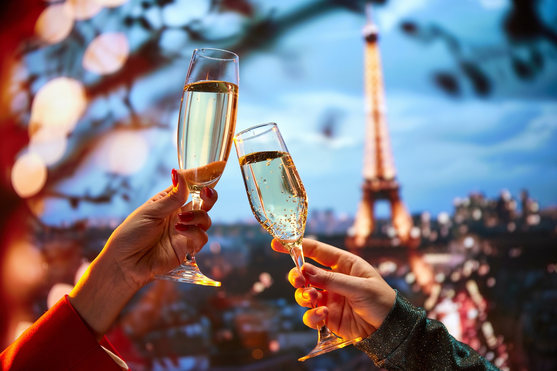 Two hands holding up glasses of champagne