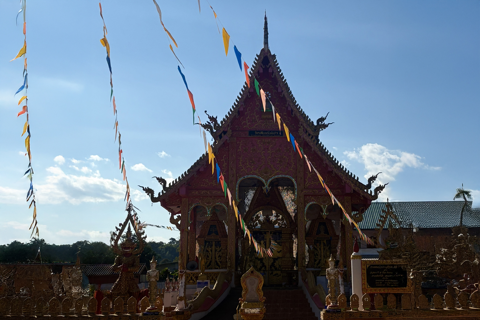 Temple in Thailand with strings of colorful paper in front