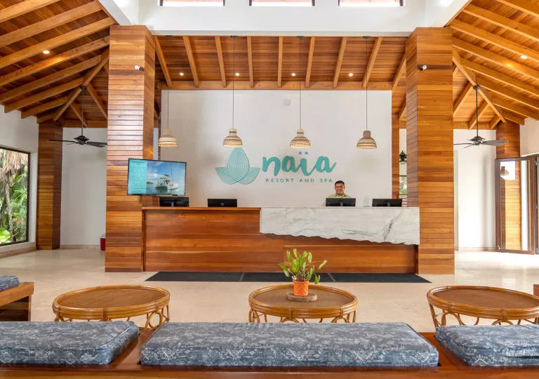 Hotel lobby with circular wooden tables and cushioned benches
