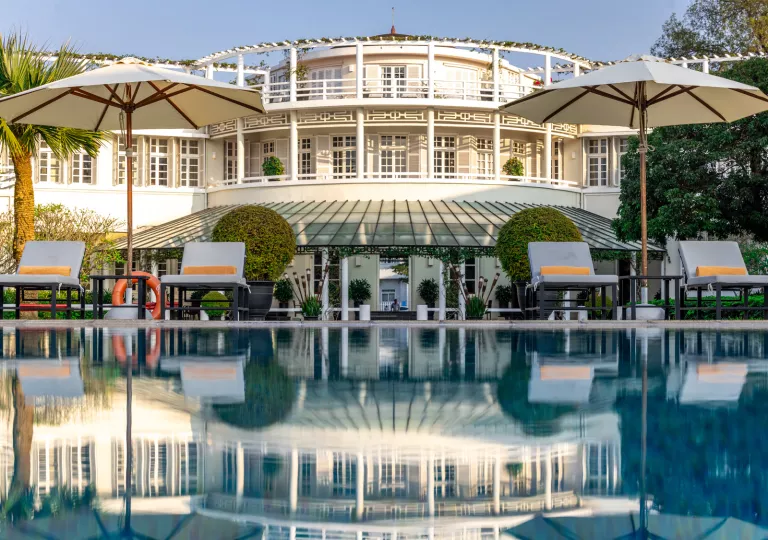 Exterior, wide view of white, castle-like building with balconies and an outdoor pool