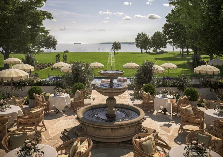 Outdoor dining area around a fountain, surrounded by a large area of grass