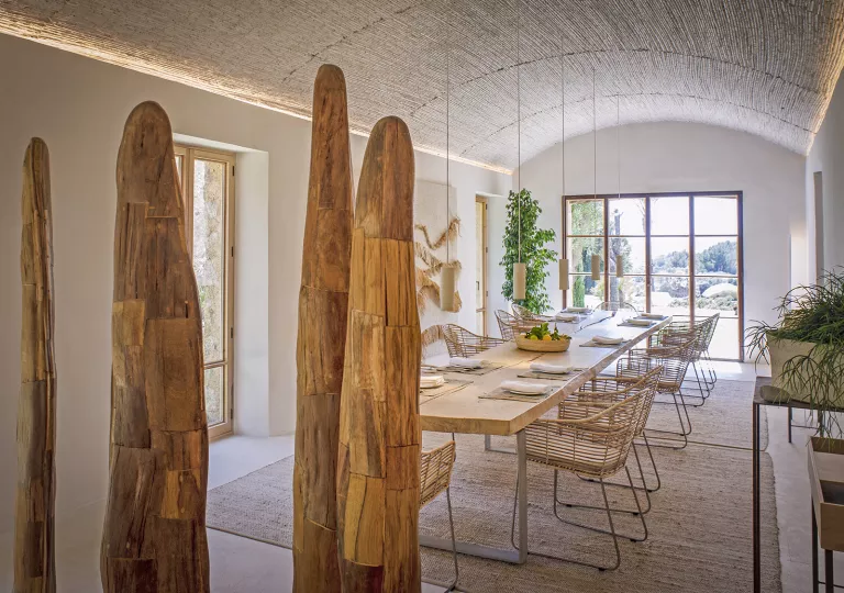 Indoor dining area with large, wooden art sculptures and large windows