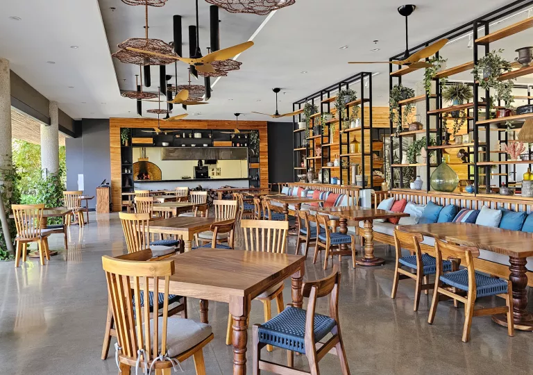 Indoor dining area with large, open walls with stone pillars