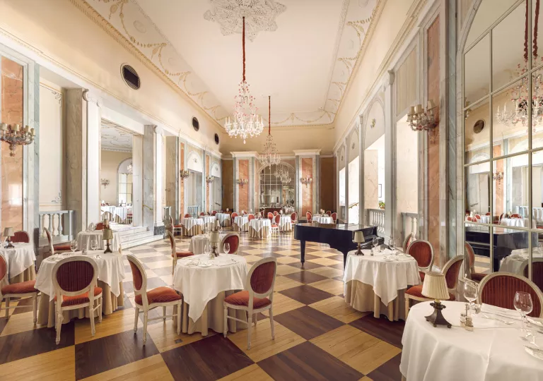 Indoor dining area with red chairs and a piano in the center