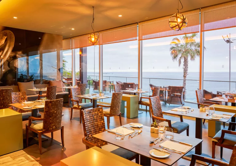 Indoor dining area with a balcony overlooking the ocean