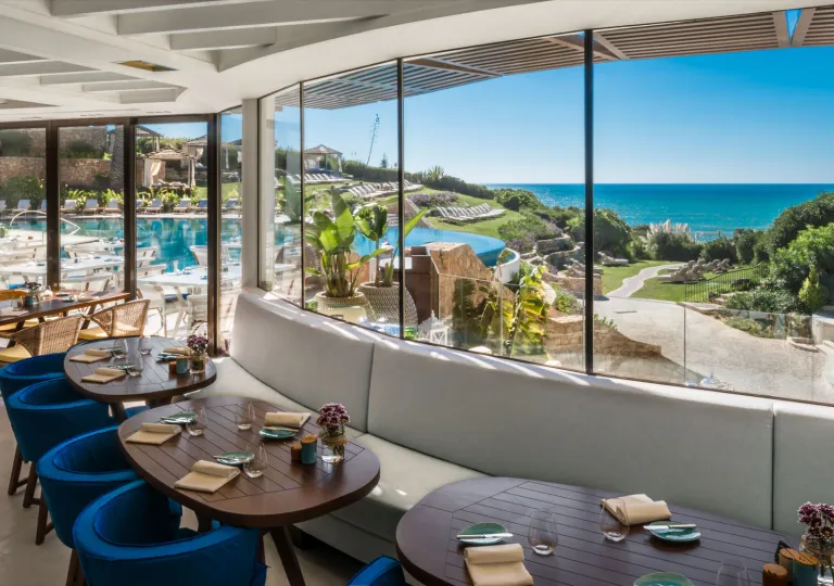 Indoor dining common area with large windows looking out to the ocean