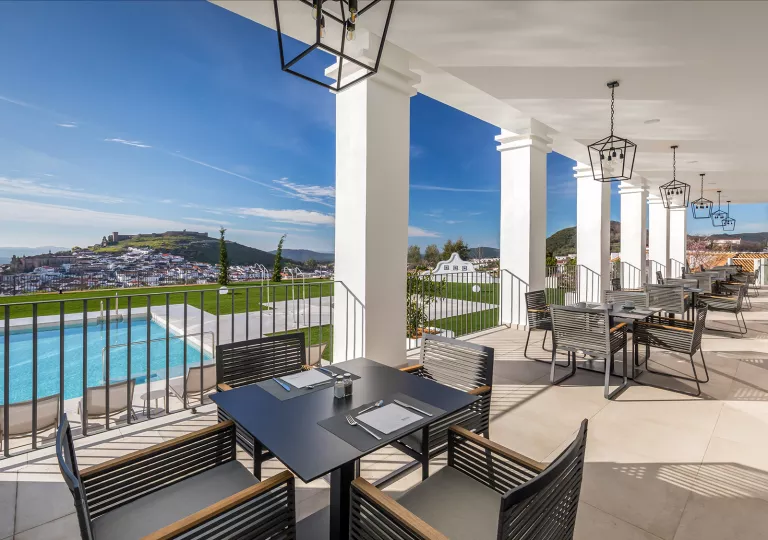 Outdoor chairs and tables overlooking the outdoor pool