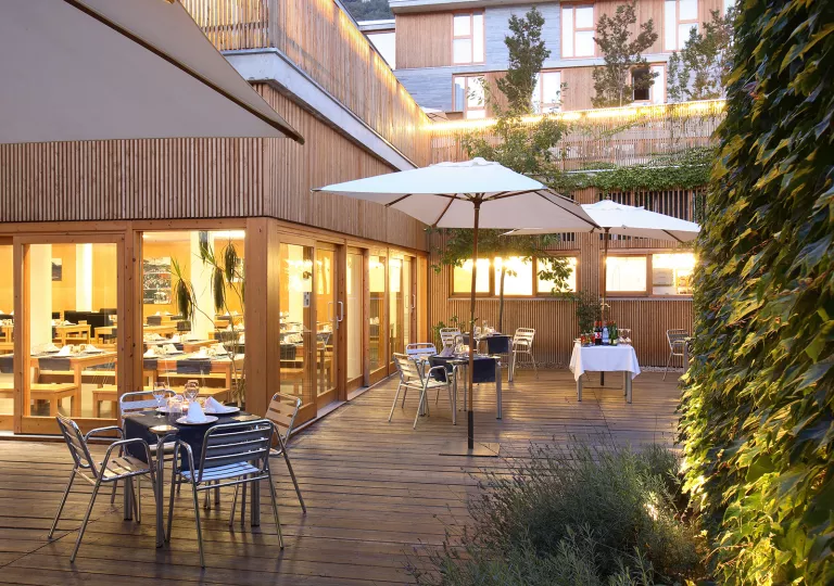 Outdoor patio with dining tables on a wooden planked floor