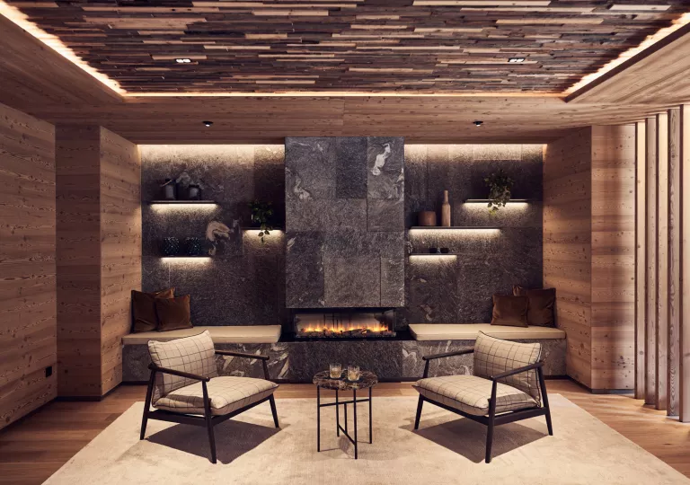 Indoor seating area with two cushioned chairs and a stone fireplace in the background