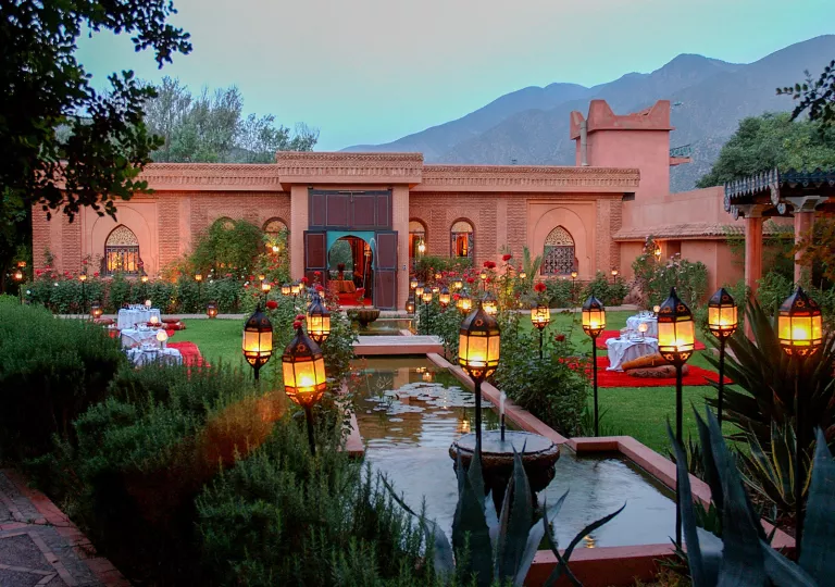 Outdoor garden in front of a stone building and a small pond