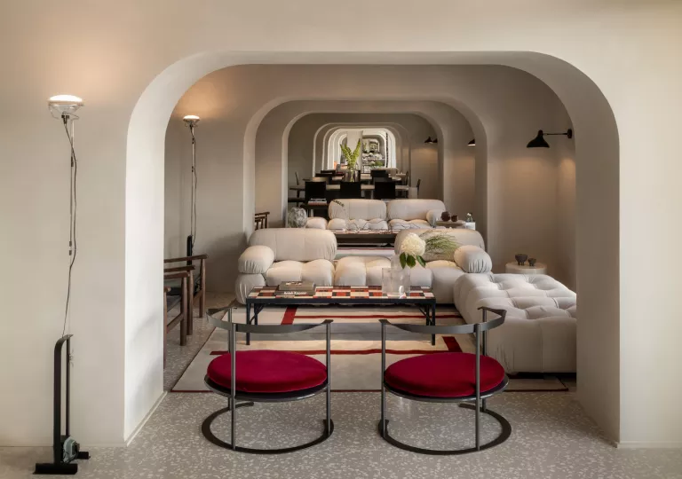 Lounge with arched hallways with white and red cushioned seating