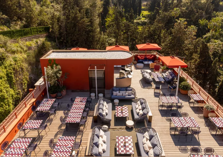 Outdoor dining area with a red building and gray cushioned seating