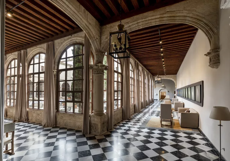 Rustic building interior with stone pillars and checkerboard flooring