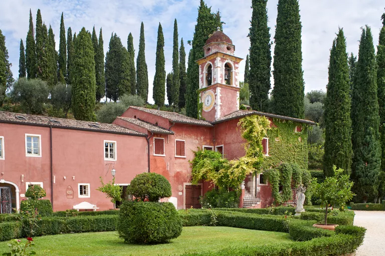 Rustic, red building with a clocktower attached to it