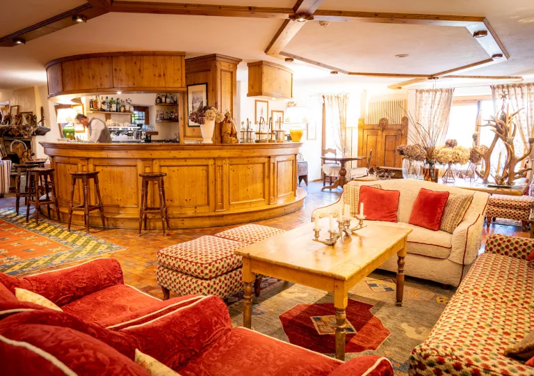 round wooden bar surrounded by large couches in wooden living room