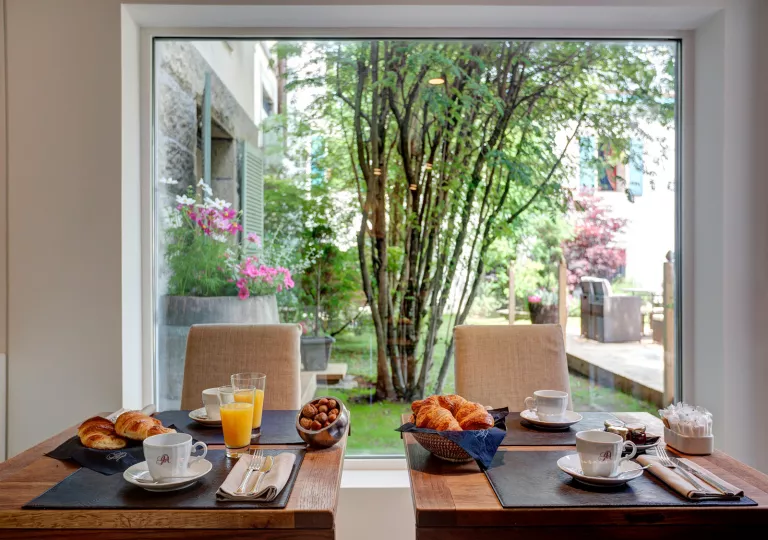 Dining table with cups of coffee and a large window in the background