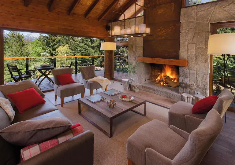 Cushioned chairs around a brick fireplace