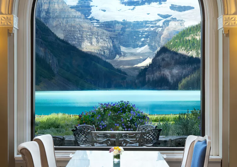 Dining table with a large window looking out to large, snow-capped mountains