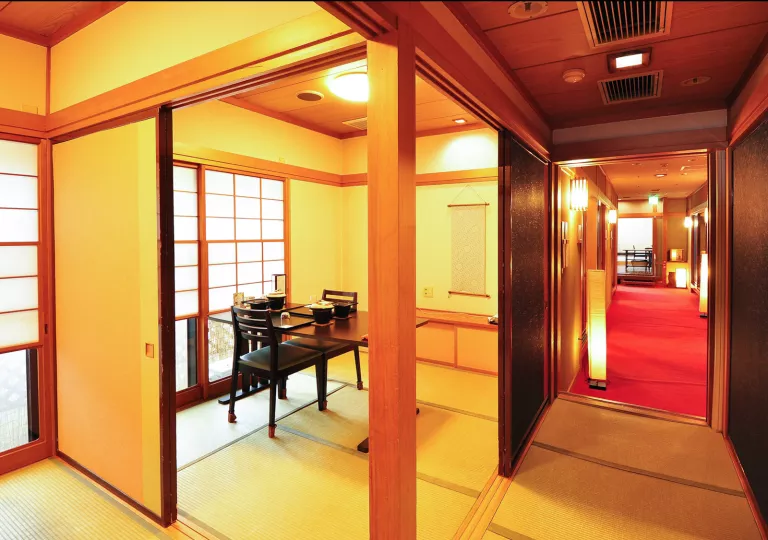 Room with tatami mats, and a dining tables with chairs surrounding it