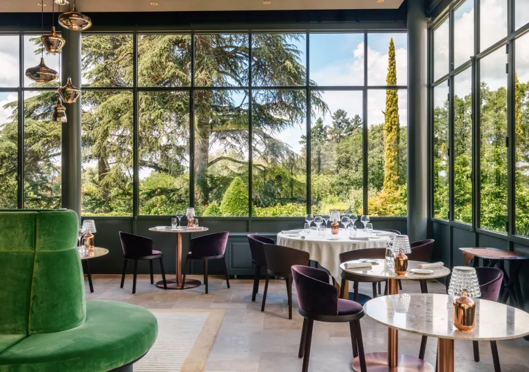 Dining area with multiple, circular tables and large windows