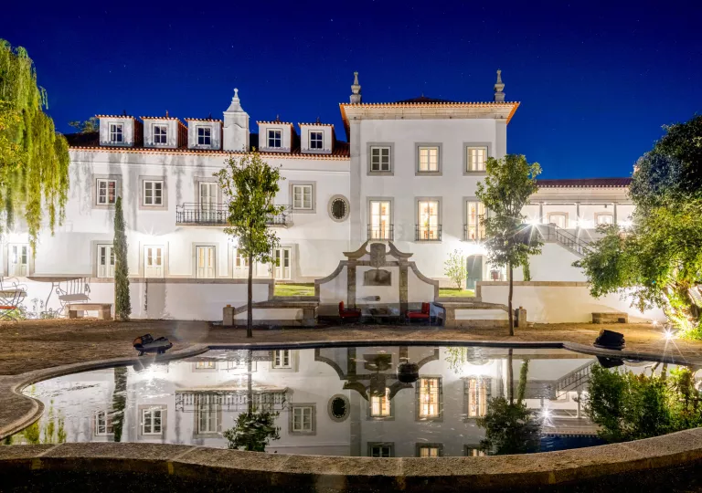 Exterior view of white building with with a fountain in front