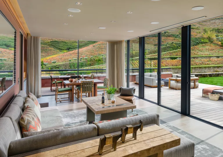 Corner room with large windows, looking out to crop-covered hills