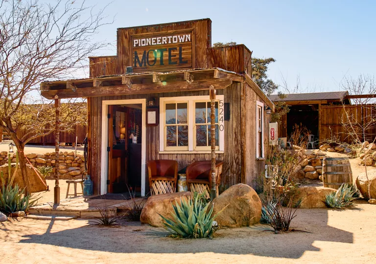 Exterior view of wooden motel entrance with a sign "Pioneertown Motel"