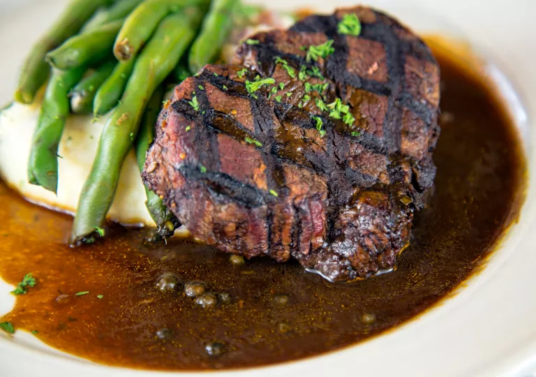 Plate with a grilled steak, peas and mashed potatoes