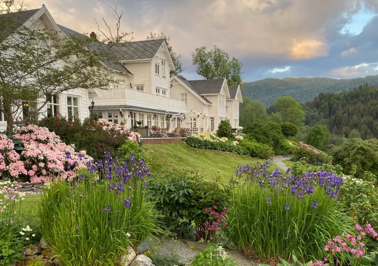 Exterior white building with a garden on a hill in front