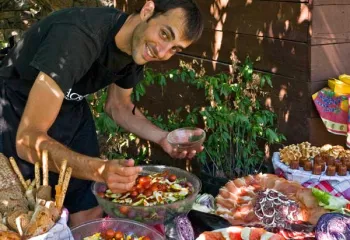 `A Backroads leader prepares a spectacular picnic lunch, featuring Spanish ham –- Jamón