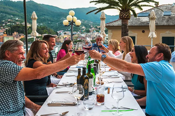 Backroads guests cheers with wine glasses at dinner
