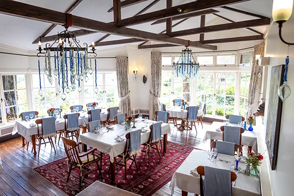 two long dining tables under chandeliers in grand dining room