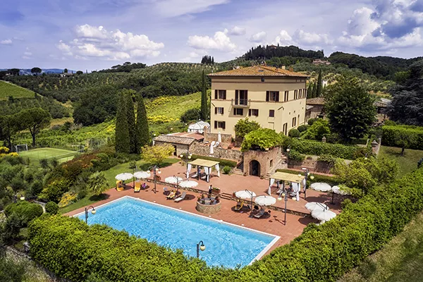 hotel with patio and pool nestled in a grassy landscape