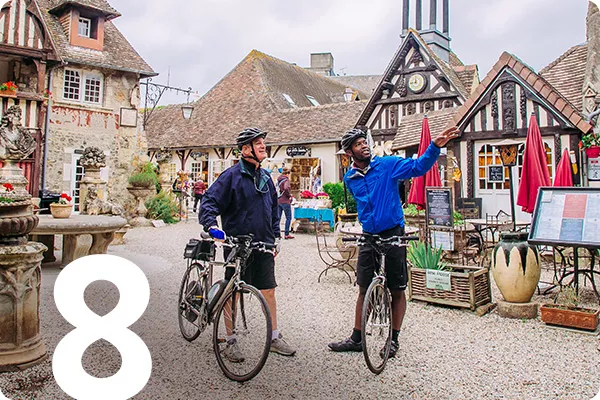 text:8; image: Two bikers stop to talk in a French village