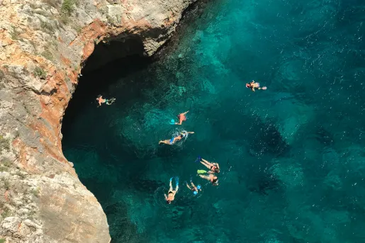 People swimming in a clear blue body of water, Portugal.