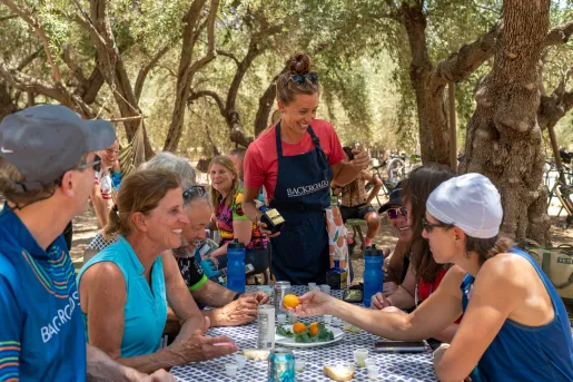 Guests at BR lunch underneath shady trees.