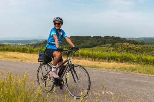 Guest cycling down countryside road.