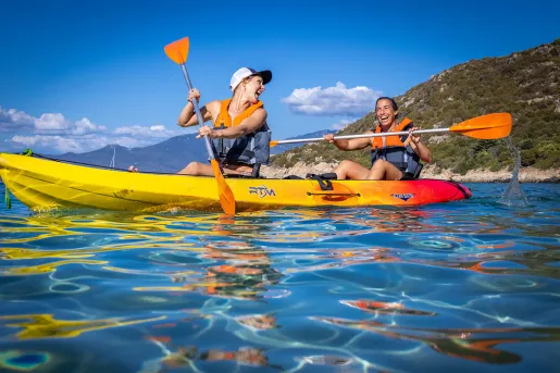 Two guests in kayak, smiling and laughing.