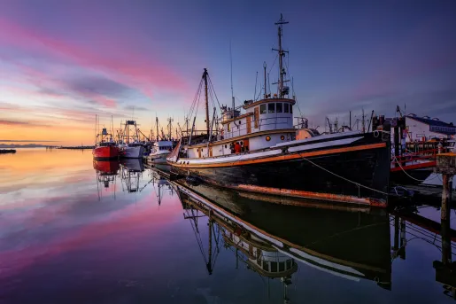 Shot of a black trawler during purple sunset.