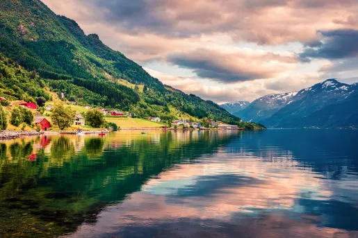 Pink sky reflected in crustal clear waters in a Norwegian fjord