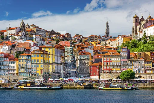 Shot of vibrant Spanish riverside town, colorful multi-story buildings.