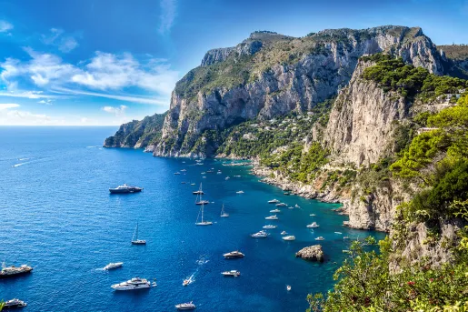 Wide shot of Amalfi Coast, boats dotting the crystal blue water.