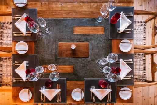Top view of a dining table with silverware and wine glasses around the table