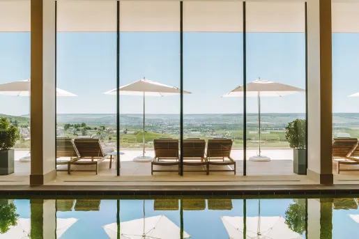 swimming pool with large windows overlooking mountains
